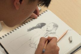 a boy drawing a sketch of a couple