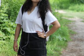 a girl wearing a white top and earphones in her ears