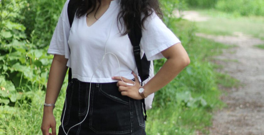 a girl wearing a white top and earphones in her ears